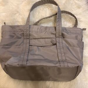 Large gray tote with outside pockets all the way around including one zippered.